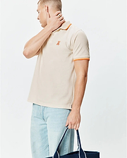 Mens Holden Pique Polo, a classic fit khaki pique knit polo with orange striped collar and sleeve cuffs, featuring a small embroidered orange Psycho Bunny skull logo on the left chest.