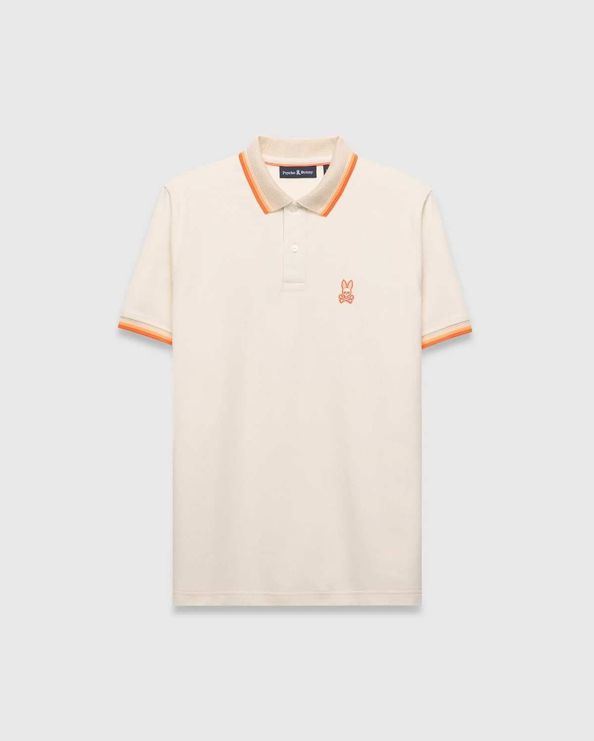 Mens Holden Pique Polo, cream classic fit with textured pique fabric, featuring an orange embroidered Psycho Bunny skull logo on the left chest, and ribbed collar/cuffs with orange and beige stripes.