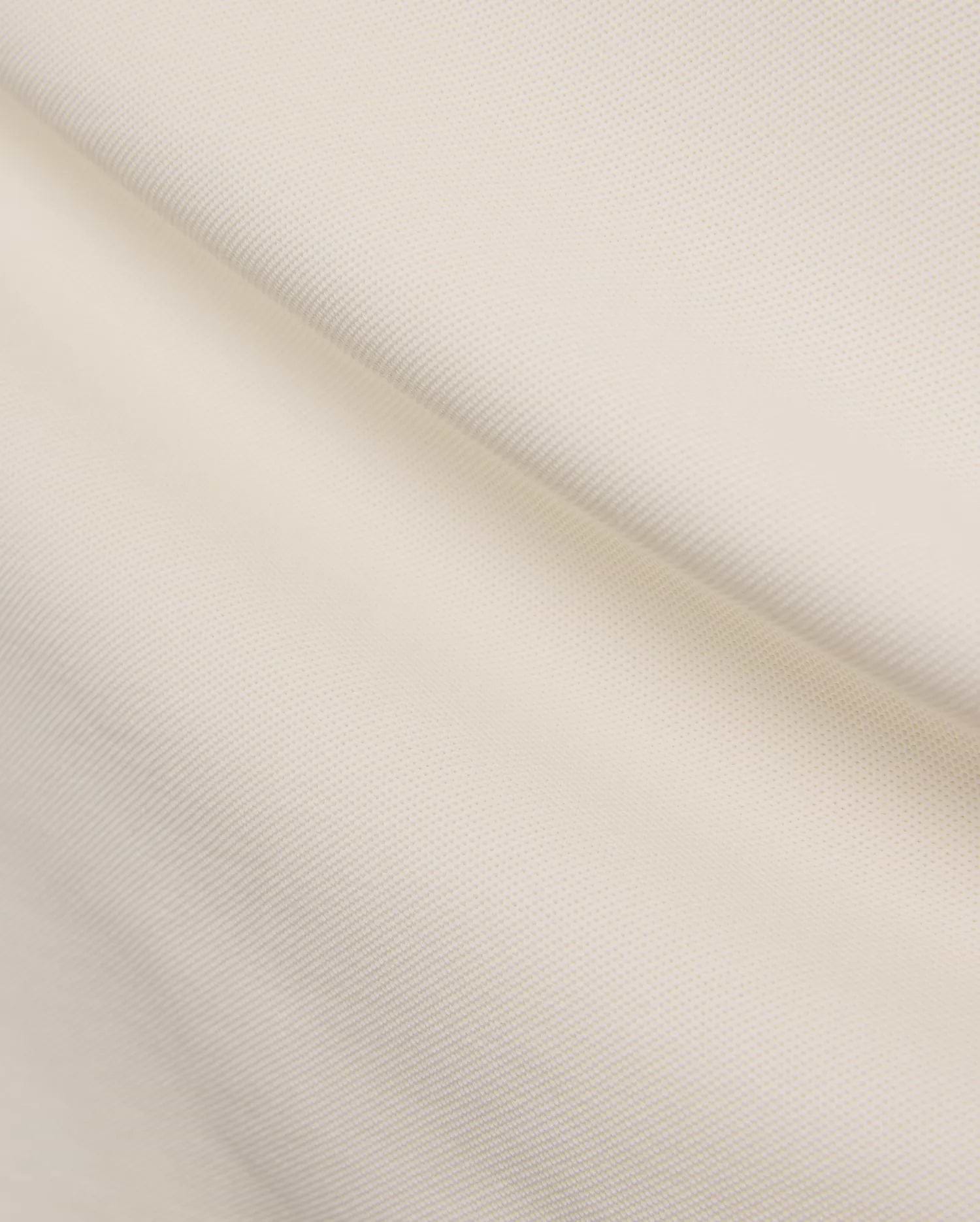 Cream Mens Holden Pique Polo, showcasing its textured pique knit fabric and the iconic small embroidered Psycho Bunny skull logo on the chest.
