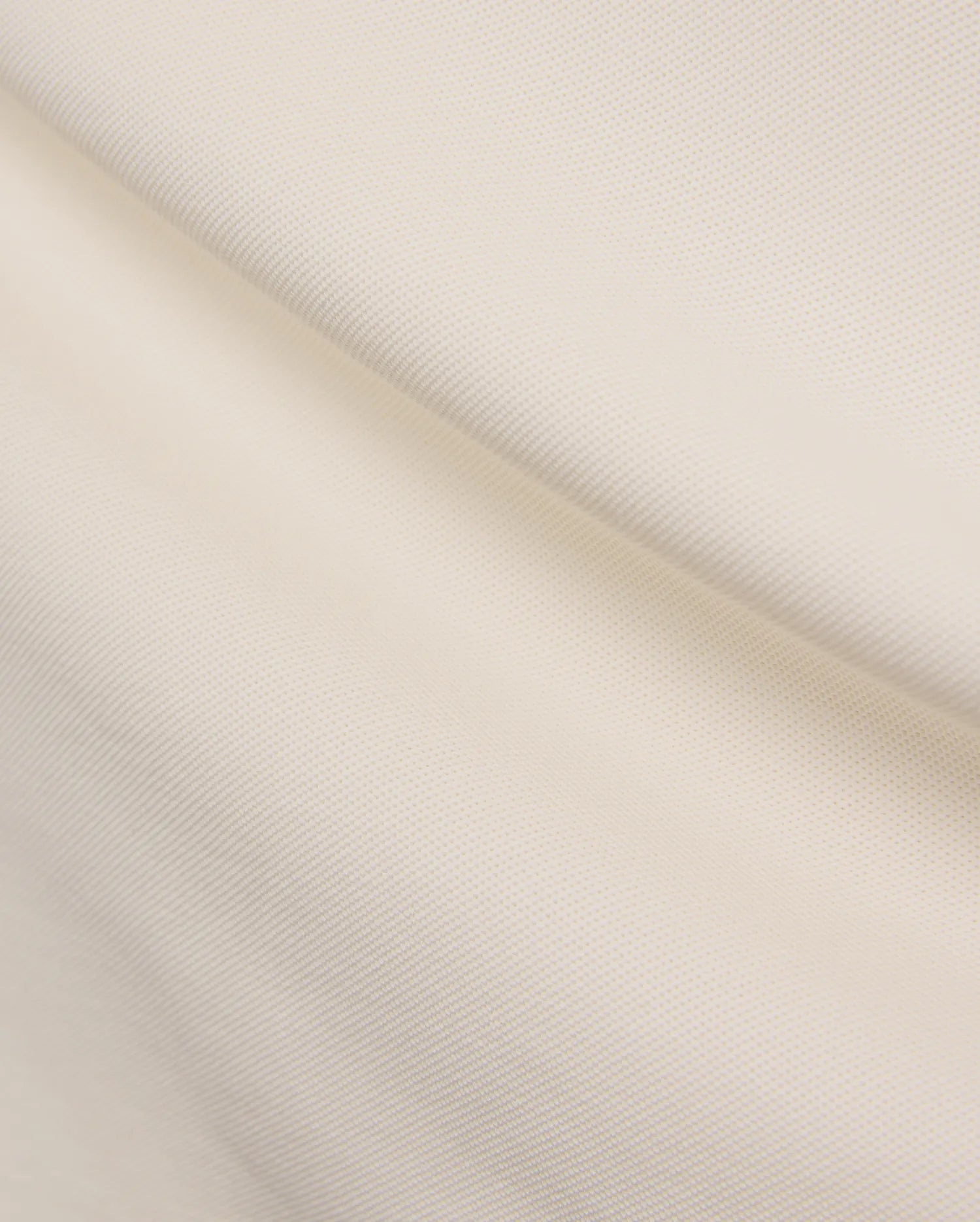 Cream Mens Holden Pique Polo, showcasing its textured pique knit fabric and the iconic small embroidered Psycho Bunny skull logo on the chest.