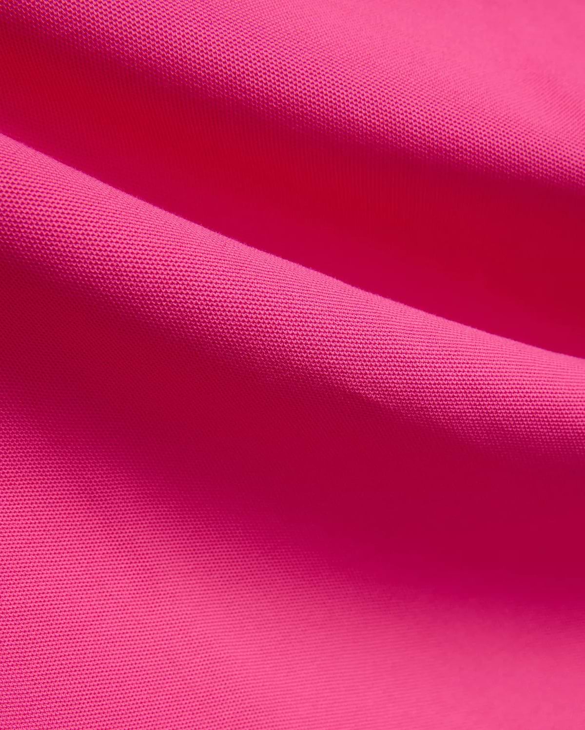 Vibrant fuchsia MENS NATE PIQUE POLO fabric, showcasing its classic textured pique knit weave, embodying Psycho Bunny's bold and refined streetwear style.