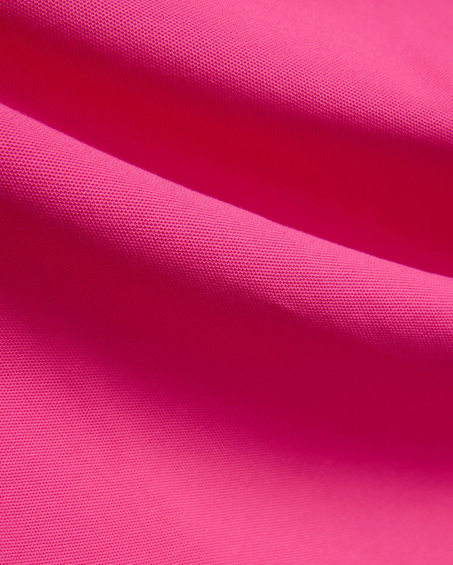 Vibrant fuchsia MENS NATE PIQUE POLO fabric, showcasing its classic textured pique knit weave, embodying Psycho Bunny's bold and refined streetwear style.