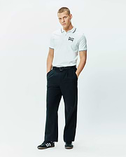 Mens Duncan Pique Polo, white pique, classic fit, with black striped collar and cuffs, featuring an embroidered black Psycho Bunny script logo on the left chest.