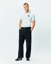 Mens Duncan Pique Polo, white pique, classic fit, with black striped collar and cuffs, featuring an embroidered black Psycho Bunny script logo on the left chest.