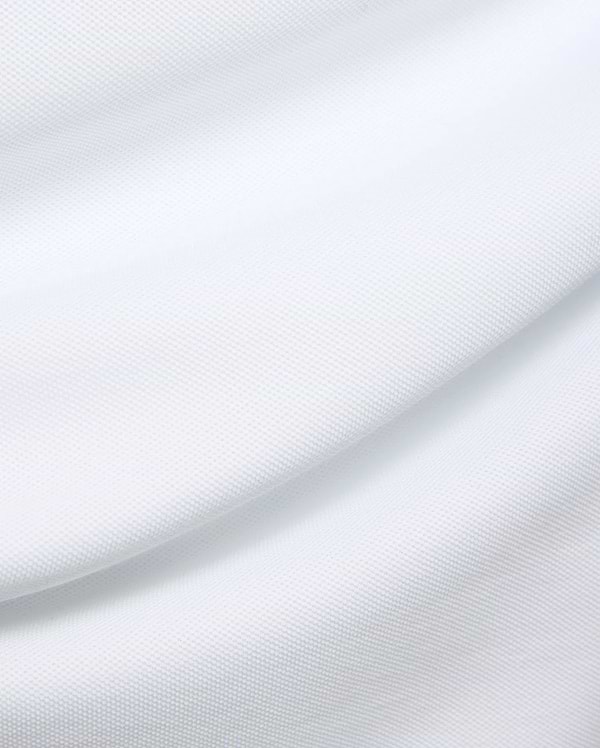 Mens Duncan Pique Polo in crisp white, a premium classic fit polo crafted from finely textured pique knit fabric, embodying Psycho Bunny's refined streetwear aesthetic.