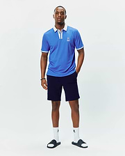 Mens Ridley Pique Polo, a bright blue classic fit pique polo shirt featuring a crisp white collar, white sleeve cuffs with tipping, and a small embroidered white Psycho Bunny skull logo on the left chest.