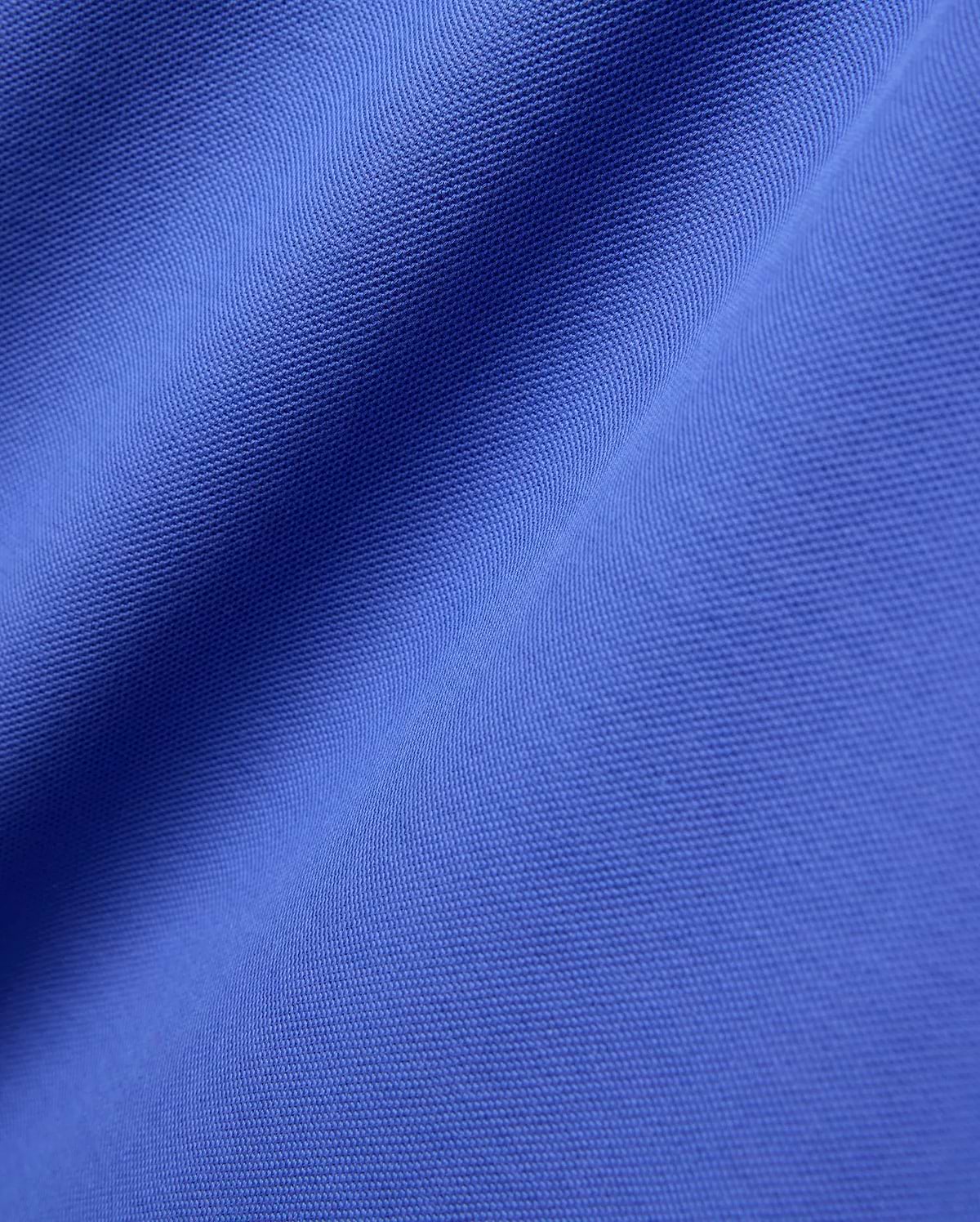Close-up of the Mens Brad Pique Polo, featuring its vibrant royal blue color and classic textured pique knit fabric with soft, flowing folds. (5)