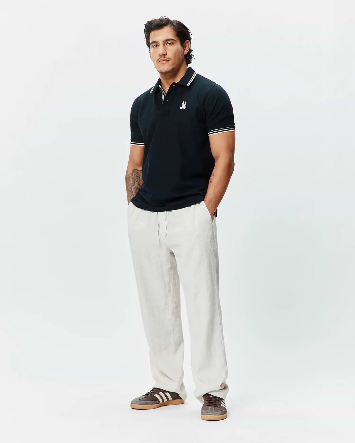 Mens Brad Pique Polo in navy, featuring a classic fit, pique texture, white tipped collar and cuffs, and a small embroidered white Psycho Bunny skull logo on the left chest.