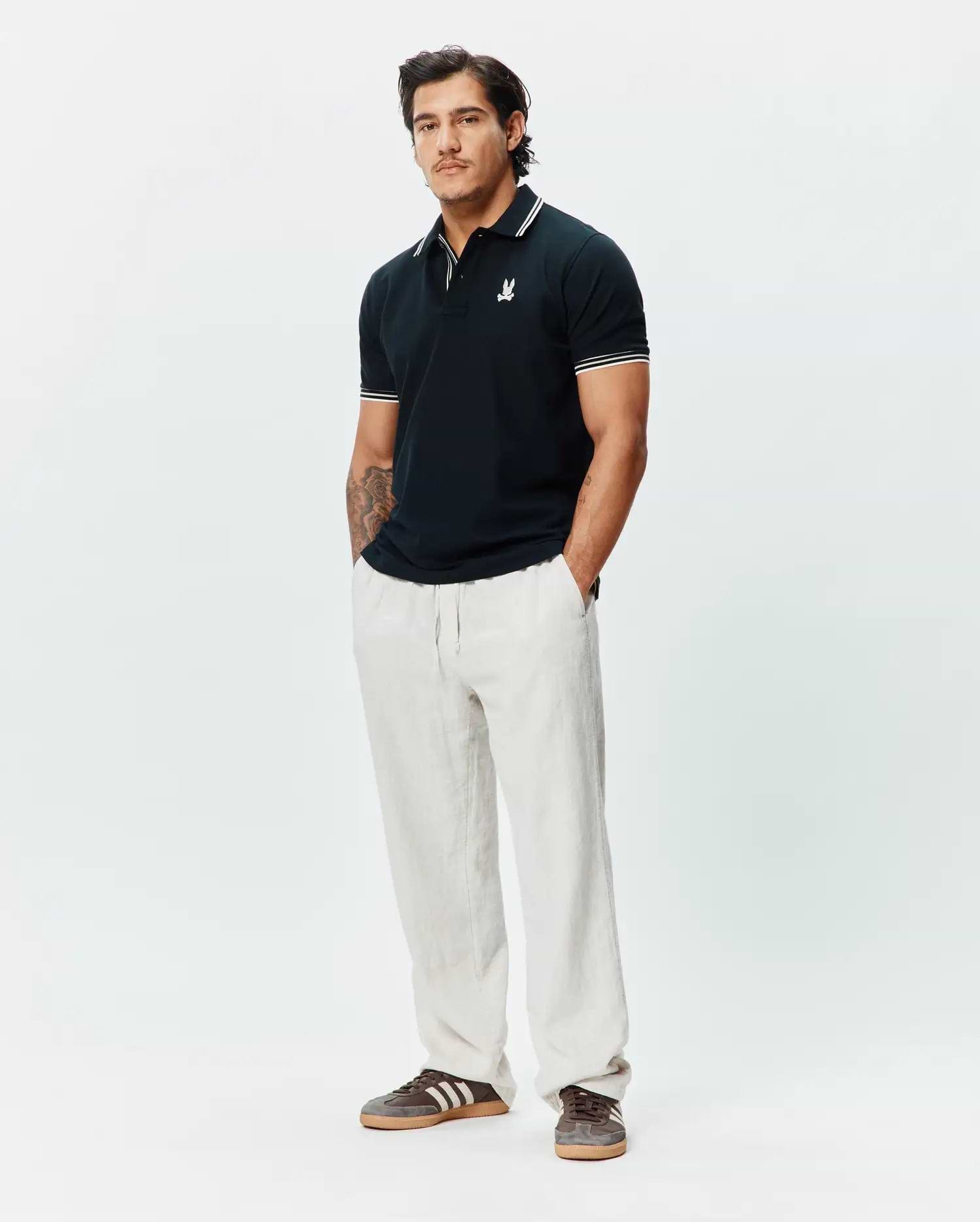 Mens Brad Pique Polo in navy, featuring a classic fit, pique texture, white tipped collar and cuffs, and a small embroidered white Psycho Bunny skull logo on the left chest.