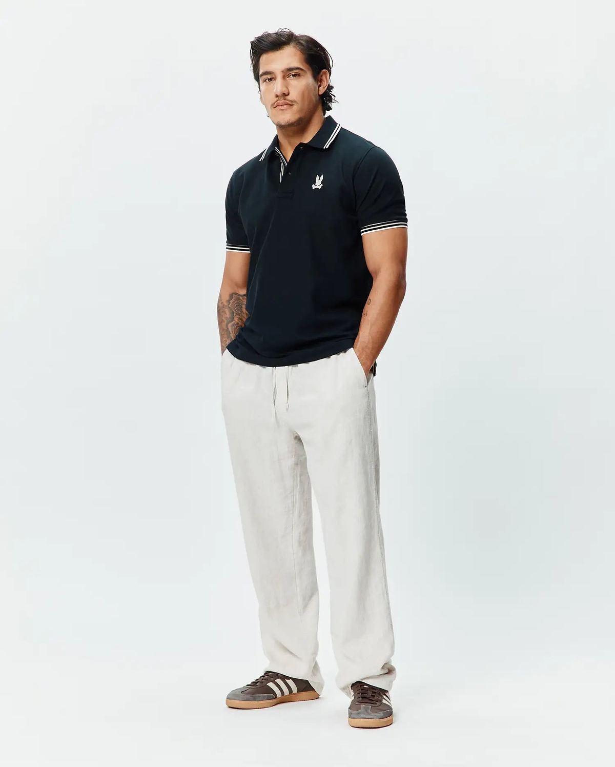 Mens Brad Pique Polo in navy, featuring a classic fit, pique texture, white tipped collar and cuffs, and a small embroidered white Psycho Bunny skull logo on the left chest.