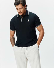 Mens Brad Pique Polo, a classic fit navy pique polo shirt with white striped collar and cuffs, featuring a small embroidered white Psycho Bunny skull logo on the left chest.