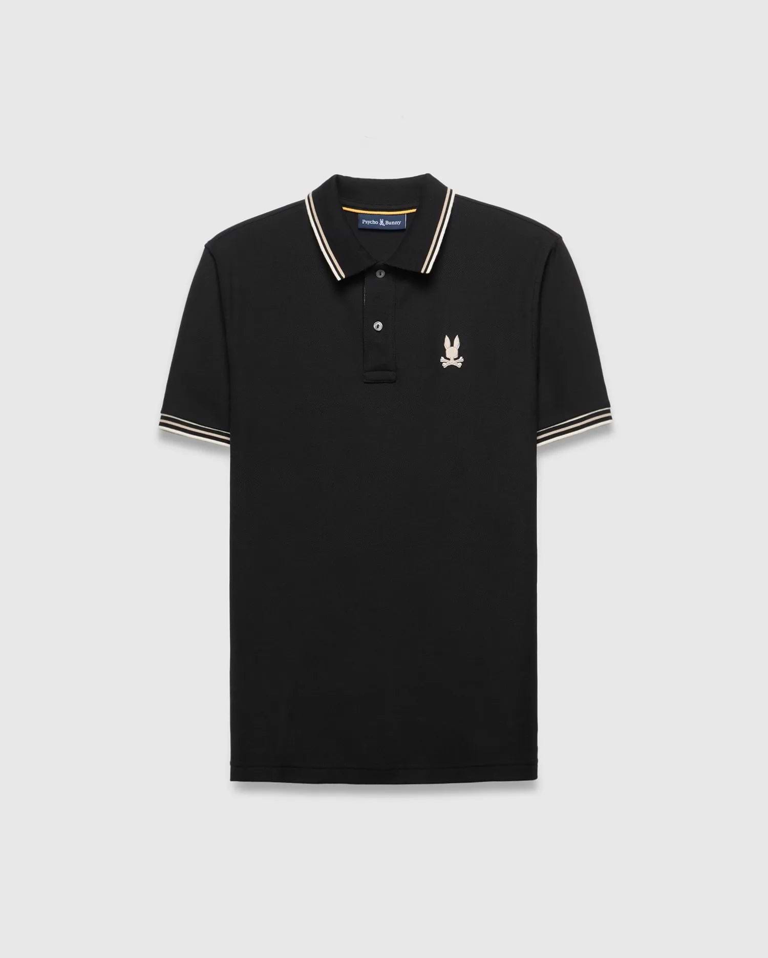 Mens Brad Pique Polo, black classic fit with white and gold striped collar and cuffs, featuring a small embroidered light pink/cream Psycho Bunny skull logo on the left chest.