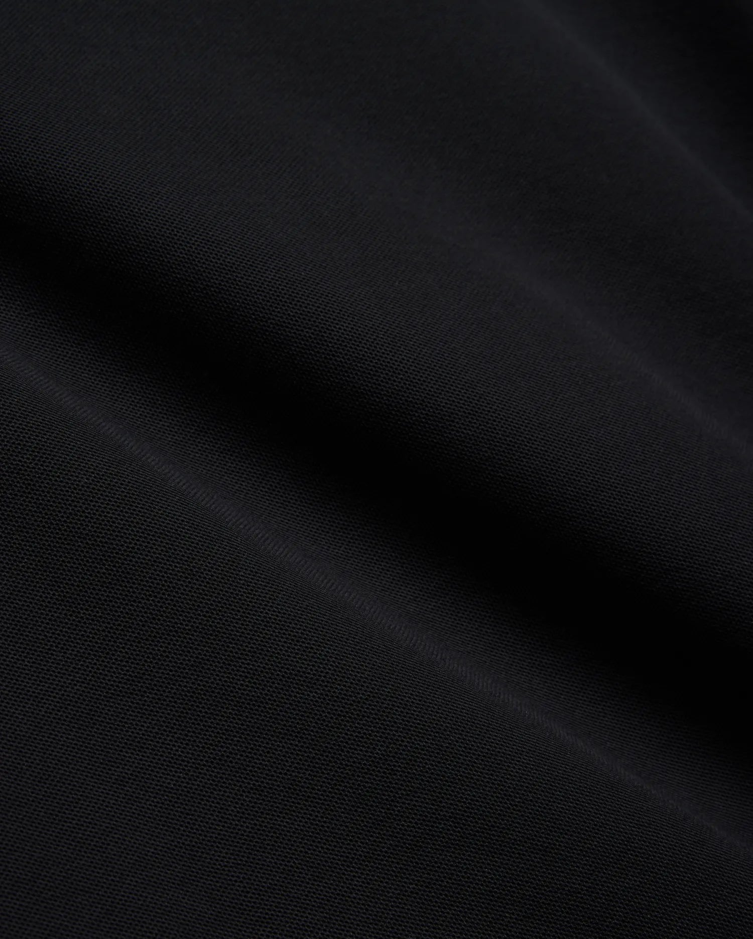 Mens Brad Pique Polo, a premium black pique knit fabric with a subtle, textured weave, showcasing the refined quality and classic style of Psycho Bunny menswear.