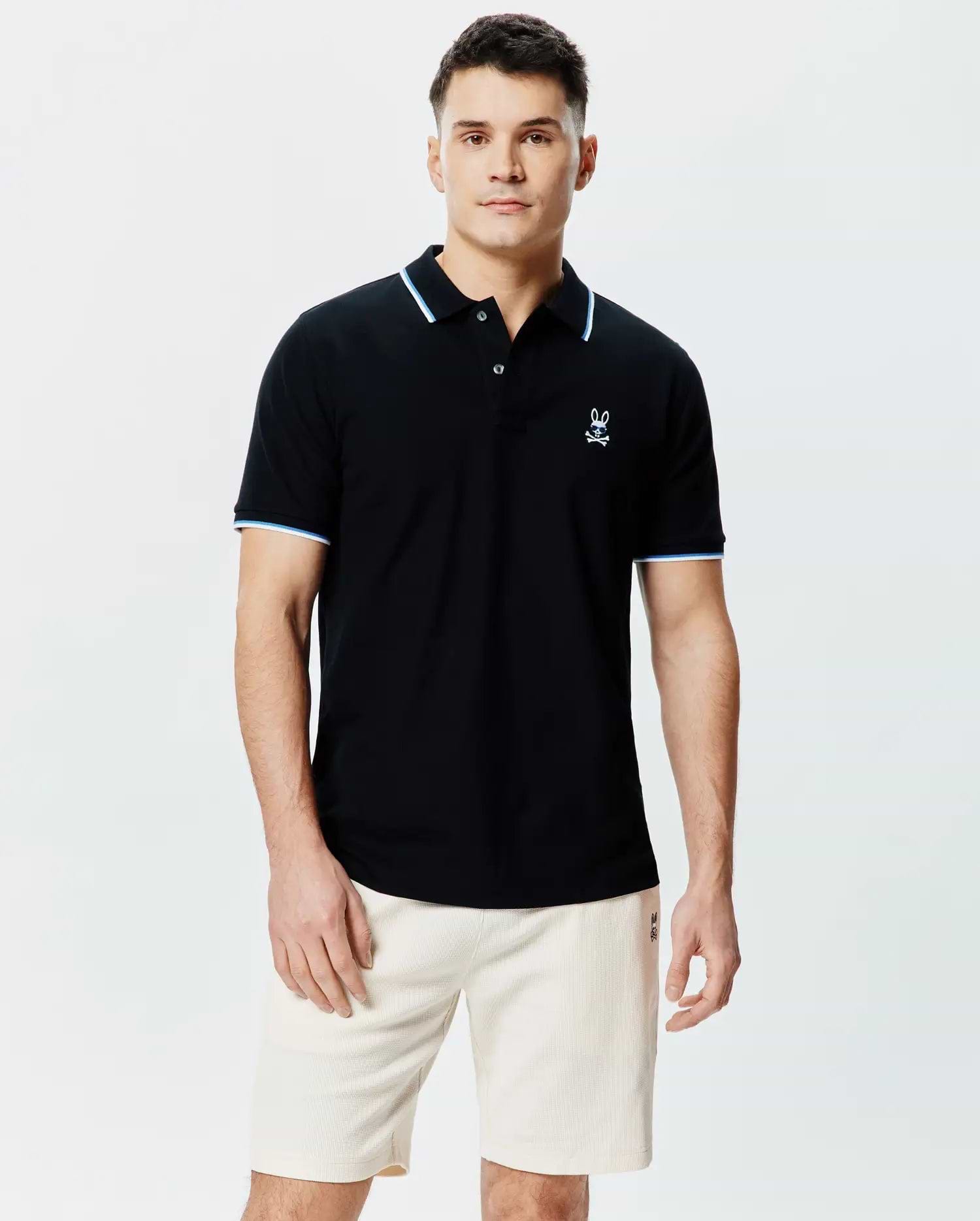 Mens Sunny Pique Polo, a classic fit black pique polo shirt with light blue and white striped collar and sleeve cuffs, featuring a small embroidered Psycho Bunny skull logo on the left chest.