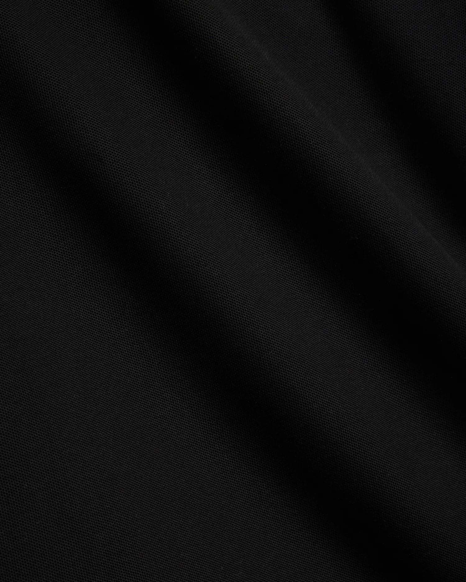 Mens Sunny Pique Polo, a premium black pique fabric polo shirt, detailed with the iconic small embroidered Psycho Bunny skull logo on the left chest.