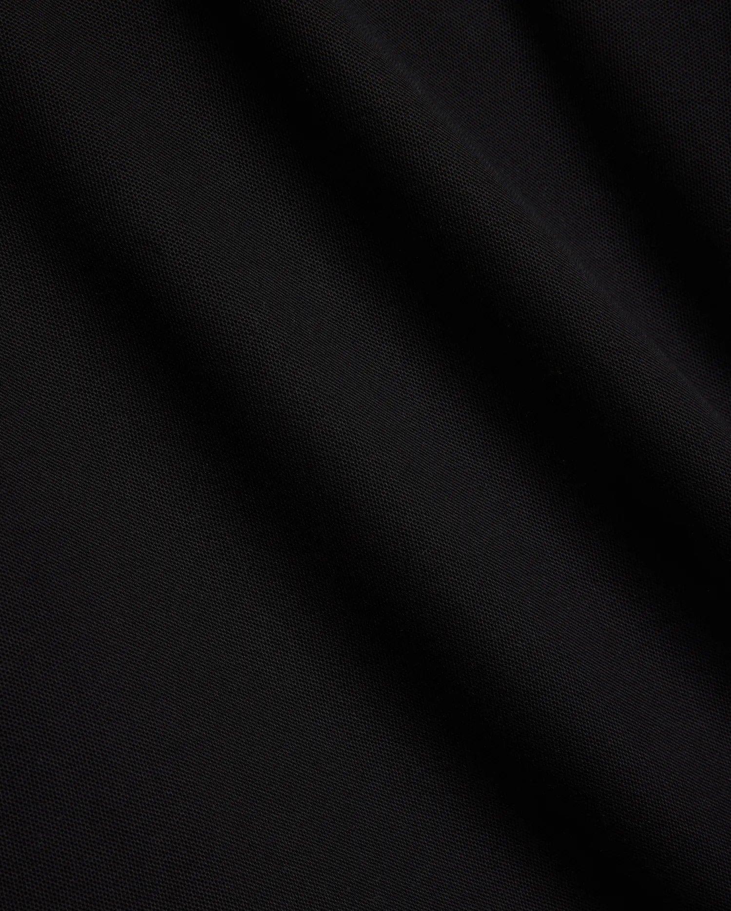Mens Sunny Pique Polo, a premium black pique fabric polo shirt, detailed with the iconic small embroidered Psycho Bunny skull logo on the left chest.