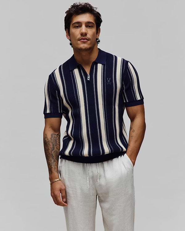 Mens Cliff Knit Zip Polo in navy and cream vertical stripes, featuring a quarter-zip placket, ribbed knit texture, classic fit, and a small embroidered Psycho Bunny skull logo on the left chest. (1)