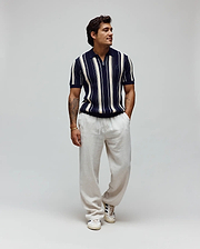 Mens Cliff Knit Zip Polo, a classic fit navy and cream vertical striped textured knit polo with a half-zip and embroidered Psycho Bunny skull logo on the left chest. (3)