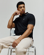 Black Mens Kenyon Lightweight Pique Polo, classic fit, with white striped ribbed collar and cuffs, and a small embroidered pink and white Psycho Bunny skull logo on the left chest.
