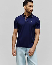 Mens Kenyon Lightweight Pique Polo in navy blue, featuring a classic fit, pique fabric, and a small embroidered white Psycho Bunny skull logo on the left chest. Collar and sleeve cuffs have orange and white stripe accents.
