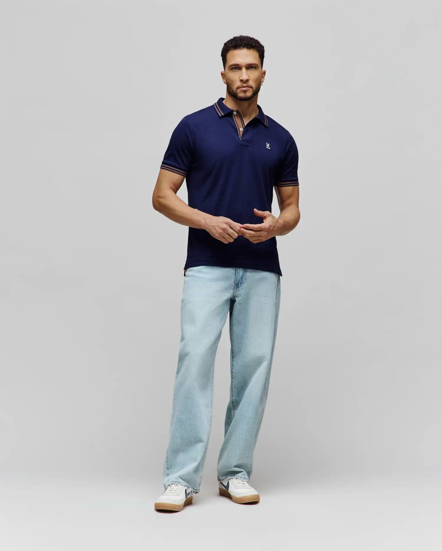 Mens Kenyon Lightweight Pique Polo in navy blue, a classic fit with textured pique fabric. Features a two-button placket, small embroidered Psycho Bunny skull logo on left chest, and red/white stripe accents on collar and cuffs.