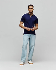 Mens Kenyon Lightweight Pique Polo in navy blue, a classic fit with textured pique fabric. Features a two-button placket, small embroidered Psycho Bunny skull logo on left chest, and red/white stripe accents on collar and cuffs.