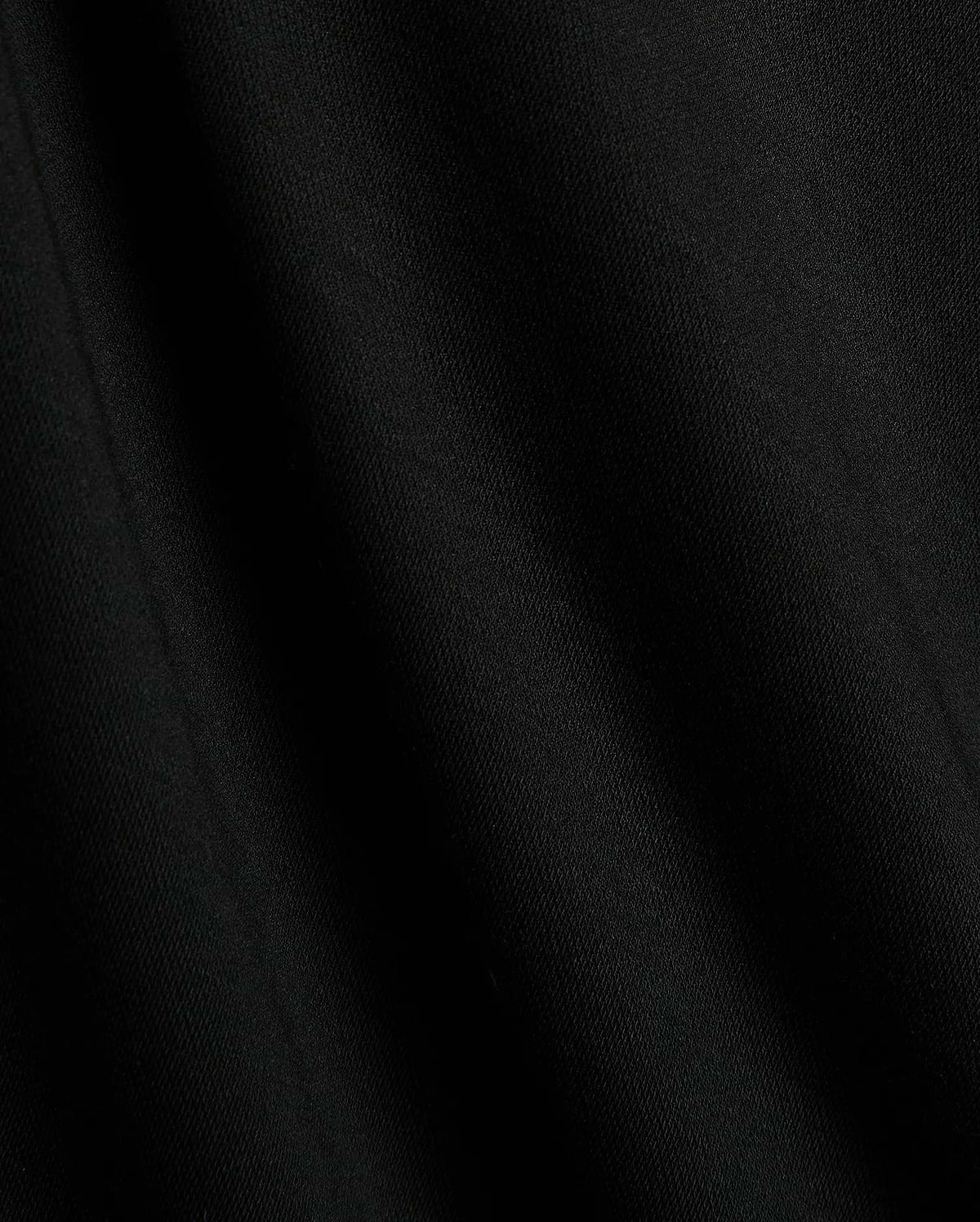 Premium black Mens Timmy Interlock Polo fabric, showcasing a smooth, dense interlock knit with subtle texture and refined drape, embodying Psycho Bunny's sophisticated streetwear style.