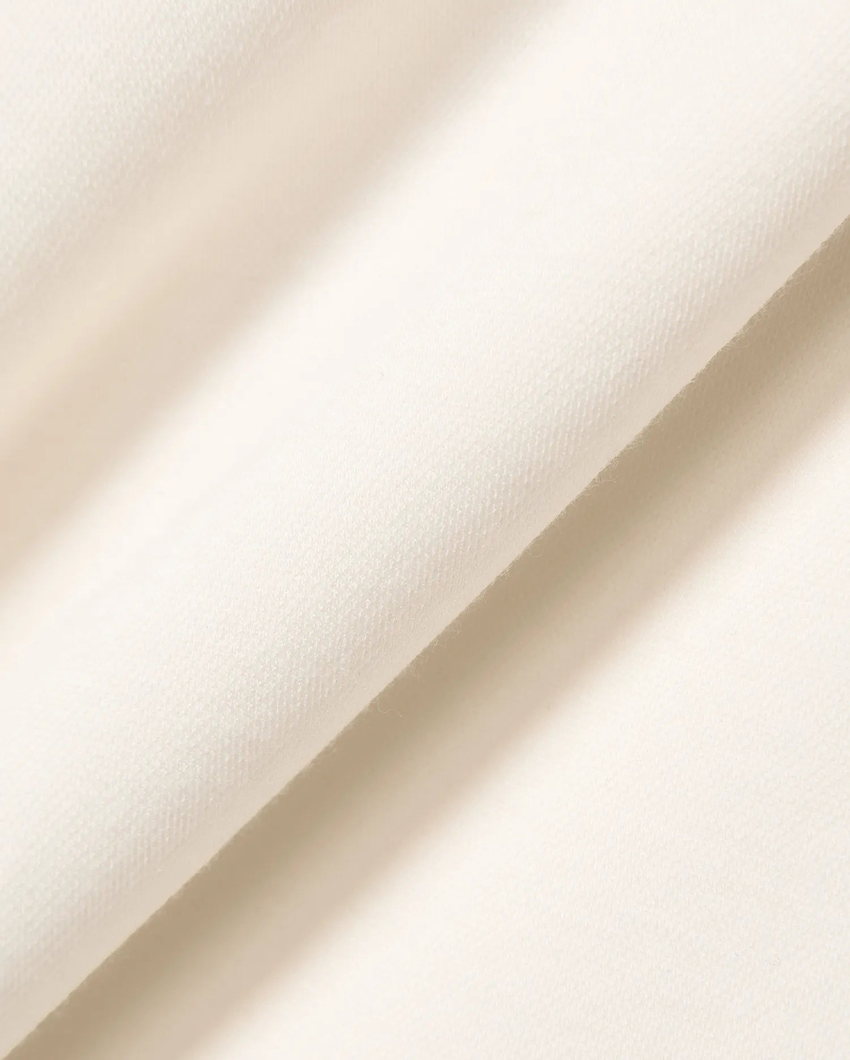 Premium cream Mens Timmy Interlock Polo fabric, featuring a refined, smooth, and dense knit texture, embodying Psycho Bunny's signature bold yet sophisticated streetwear aesthetic.