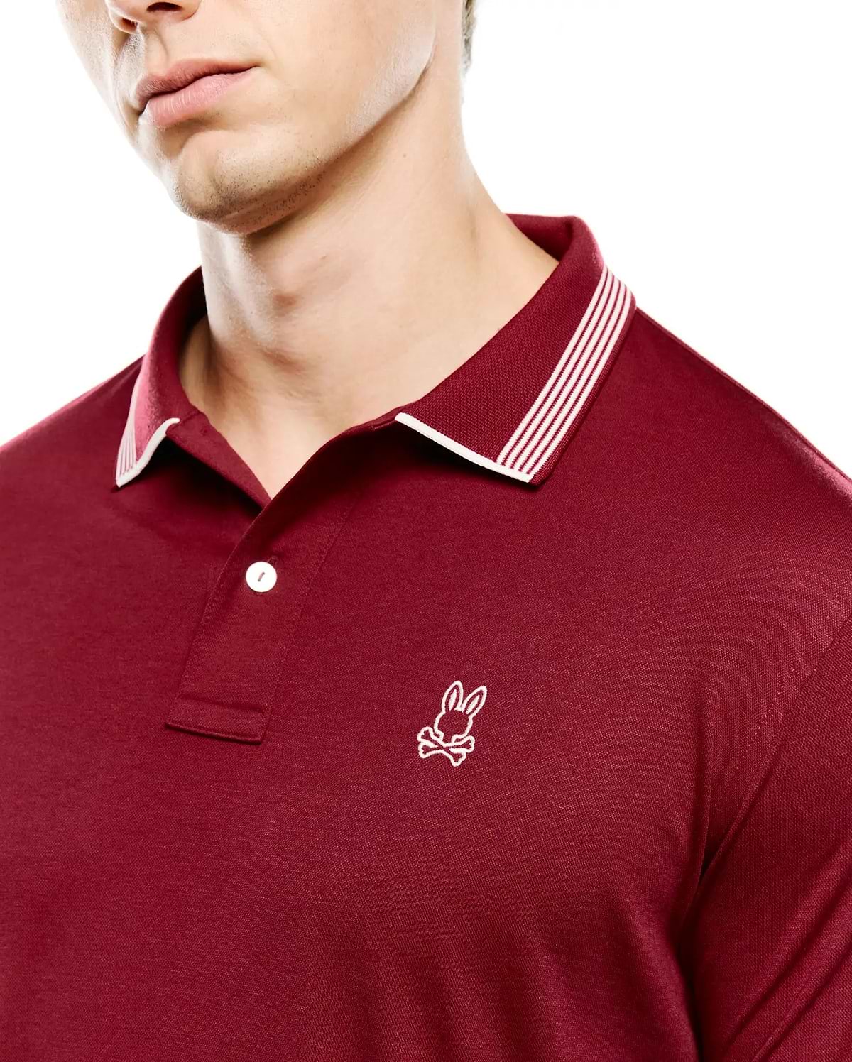 Mens Timmy Interlock Polo in deep maroon, featuring a smooth interlock knit fabric, classic fit, ribbed collar with white tipping and three white stripes, and a small white embroidered Psycho Bunny skull logo on the left chest.