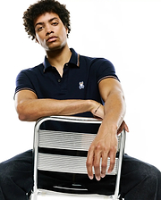 Mens Jaydon Pique Polo, navy classic fit pique polo with orange and white striped trim on collar and cuffs, featuring a small embroidered Psycho Bunny skull logo on the left chest.