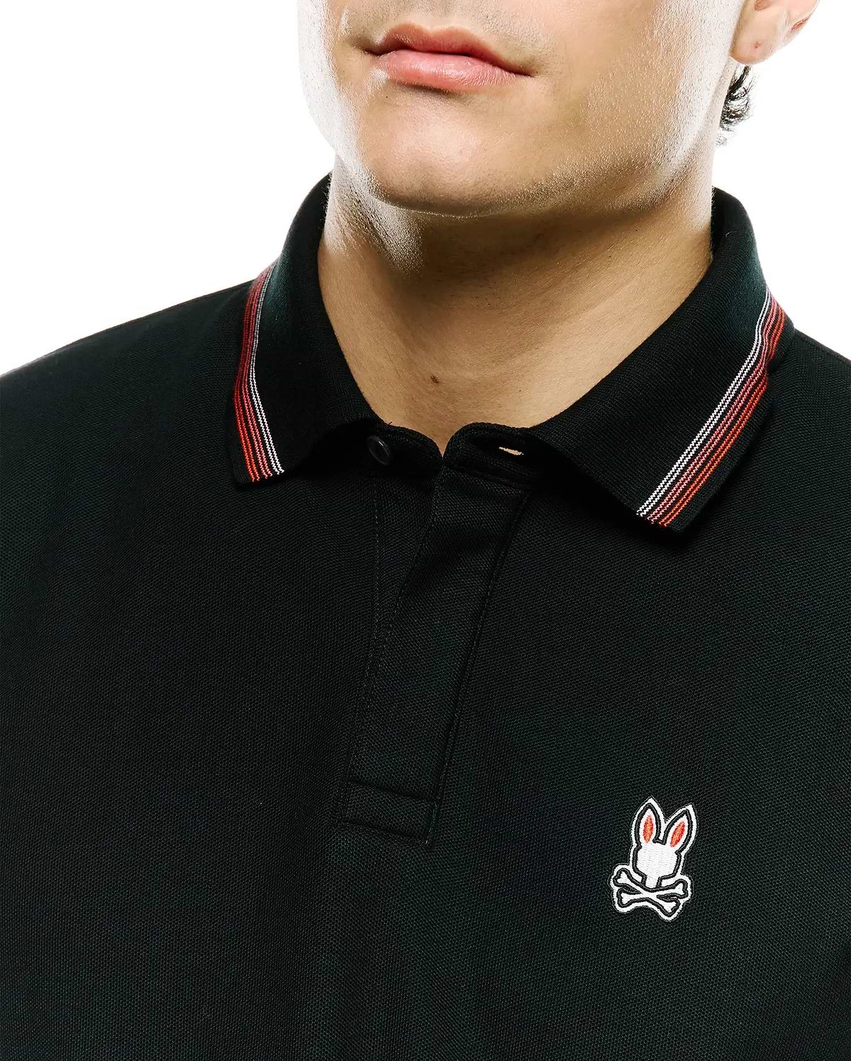 Black Mens Jaydon Pique Polo with classic fit, pique texture, and a small embroidered Psycho Bunny skull logo on the left chest. Collar features red and white stripe accents.