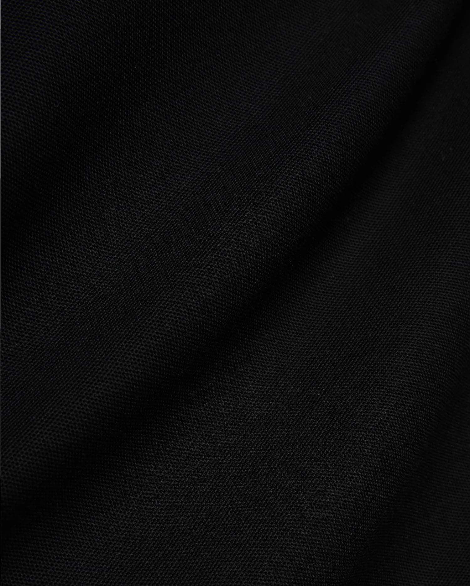 Mens Jaydon Pique Polo, a luxurious black polo crafted from premium, finely woven pique fabric, showcasing its distinctive texture and subtle draping, embodying Psycho Bunny's sophisticated style.