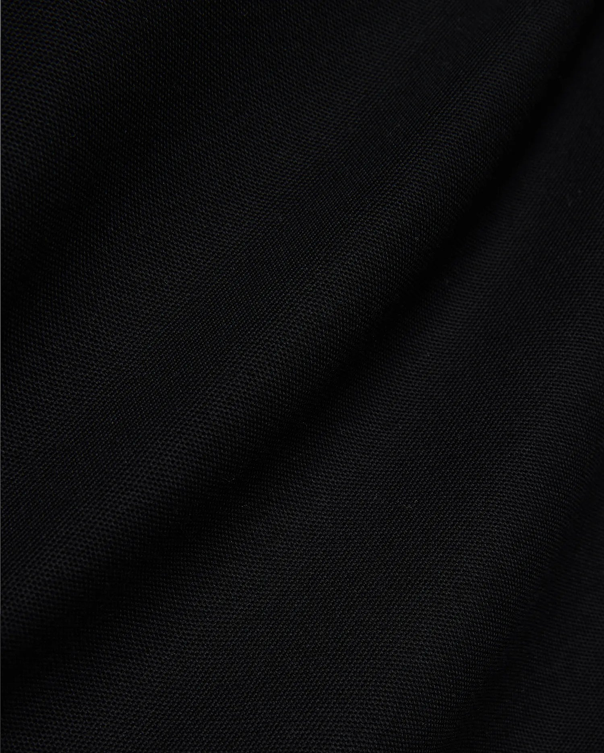 Mens Jaydon Pique Polo, a luxurious black polo crafted from premium, finely woven pique fabric, showcasing its distinctive texture and subtle draping, embodying Psycho Bunny's sophisticated style.