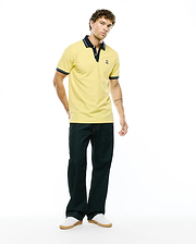 Mens Jaydon Pique Polo in bright yellow, featuring a classic fit, navy blue collar, striped navy and white cuffs, and a small embroidered Psycho Bunny skull logo on the left chest.