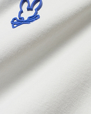 Men's Joji Performance Polo in crisp white, breathable pique knit fabric, showcasing the iconic, raised blue Psycho Bunny skull logo on the chest.
