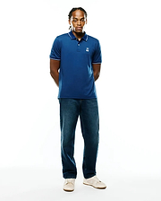 Men's Joji Performance Polo, deep blue performance jersey with white tipped collar and cuffs, featuring a small embroidered white Psycho Bunny skull logo on the left chest, classic fit.