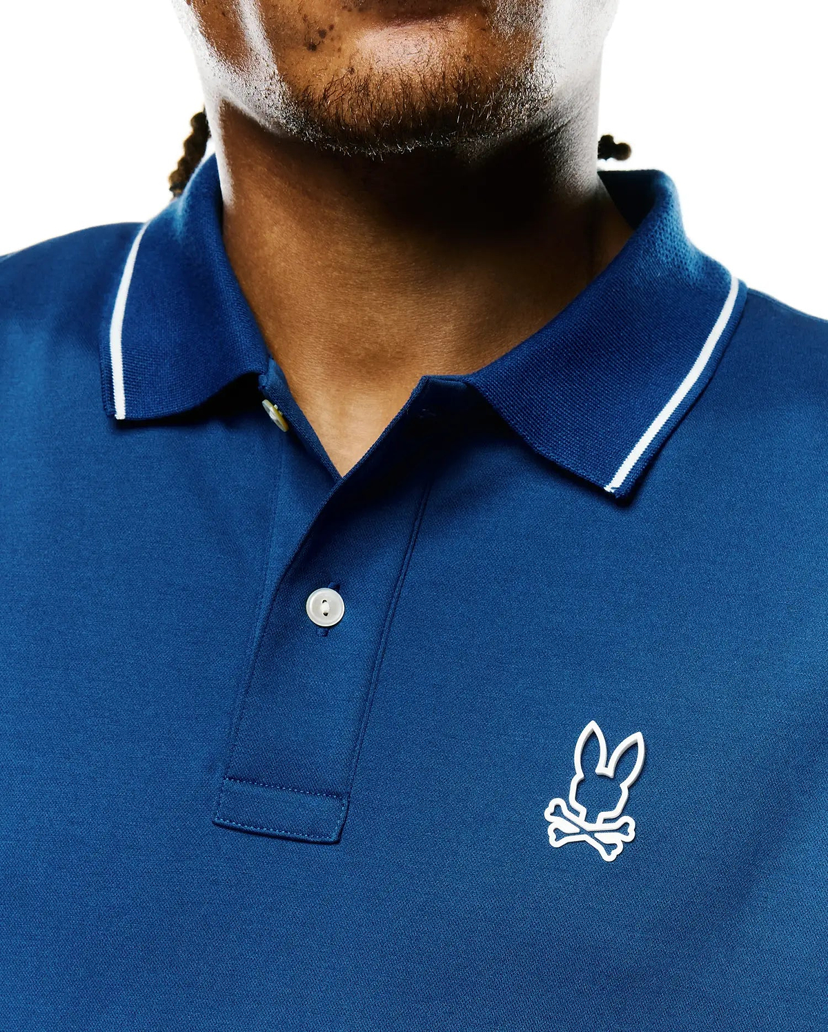 Men's Joji Performance Polo in deep blue performance pique, featuring a ribbed collar with white tipping, two-button placket, and an embroidered white Psycho Bunny skull logo on the left chest.