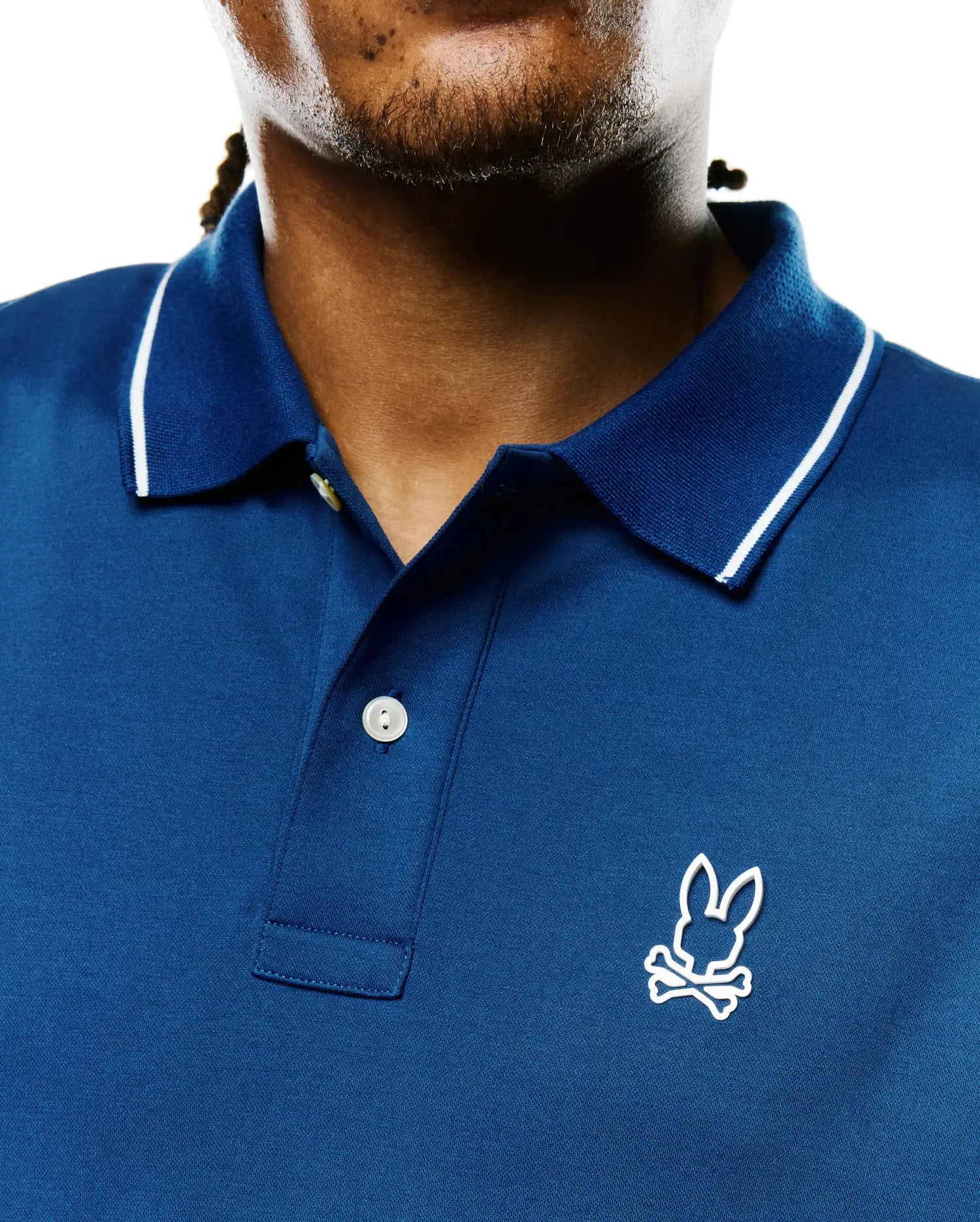 Men's Joji Performance Polo in deep blue performance pique, featuring a ribbed collar with white tipping, two-button placket, and an embroidered white Psycho Bunny skull logo on the left chest.