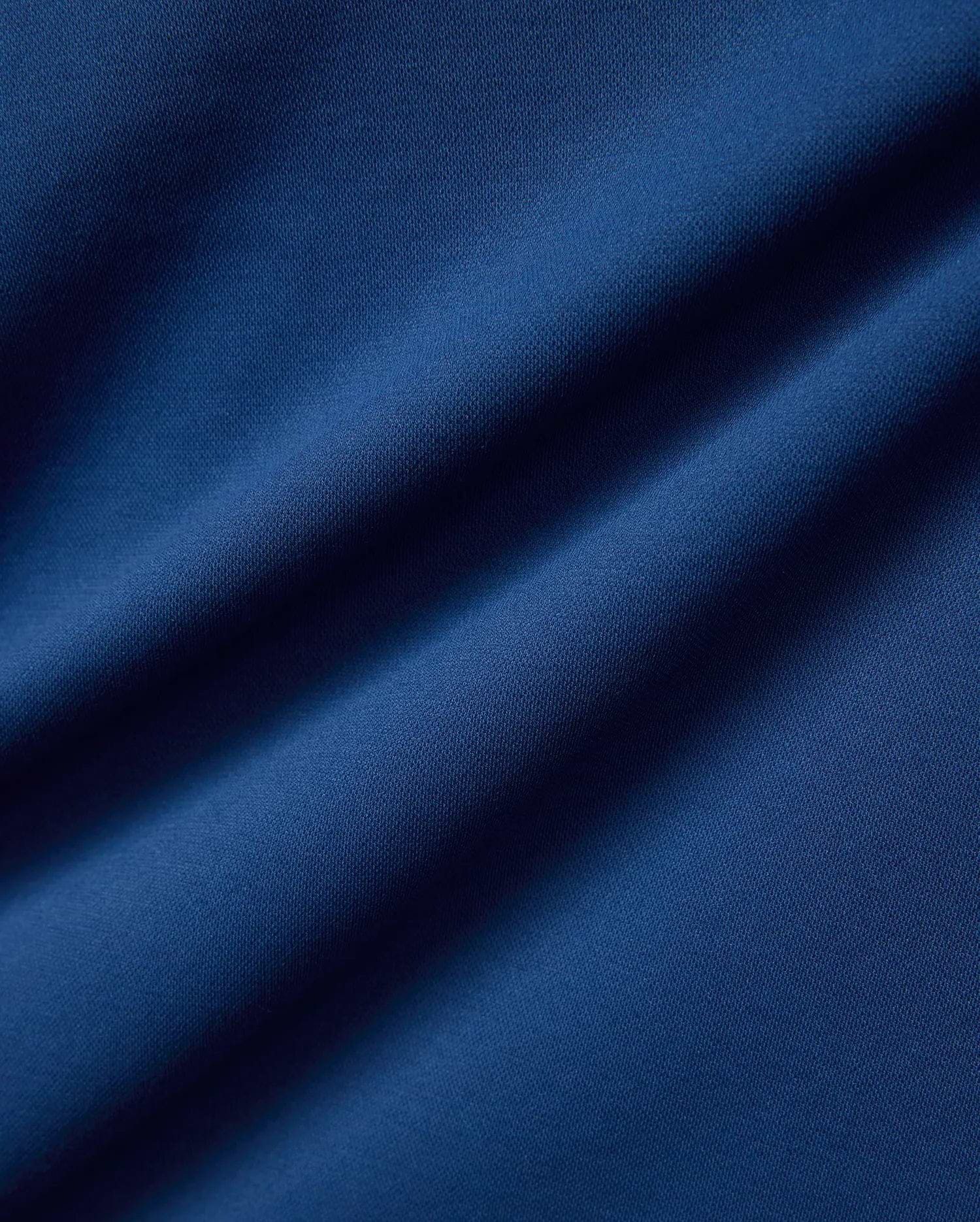 Psycho Bunny Mens Joji Performance Polo in deep blue, featuring a finely textured pique knit fabric, embodying refined streetwear style.