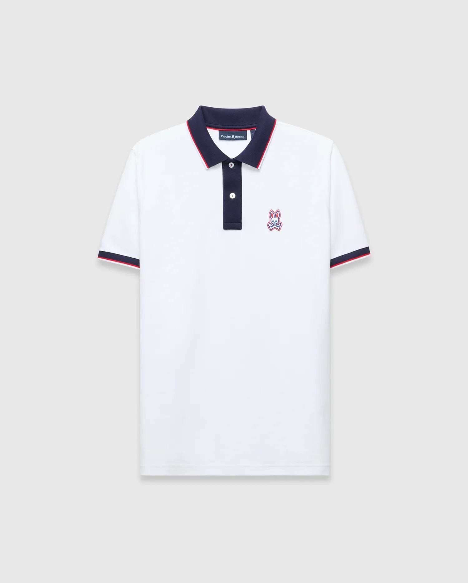 Mens John Pique Polo, a classic fit white pique polo with navy collar and placket, red tipping, navy ribbed cuffs with red stripe, and an embroidered Psycho Bunny skull logo on the left chest.