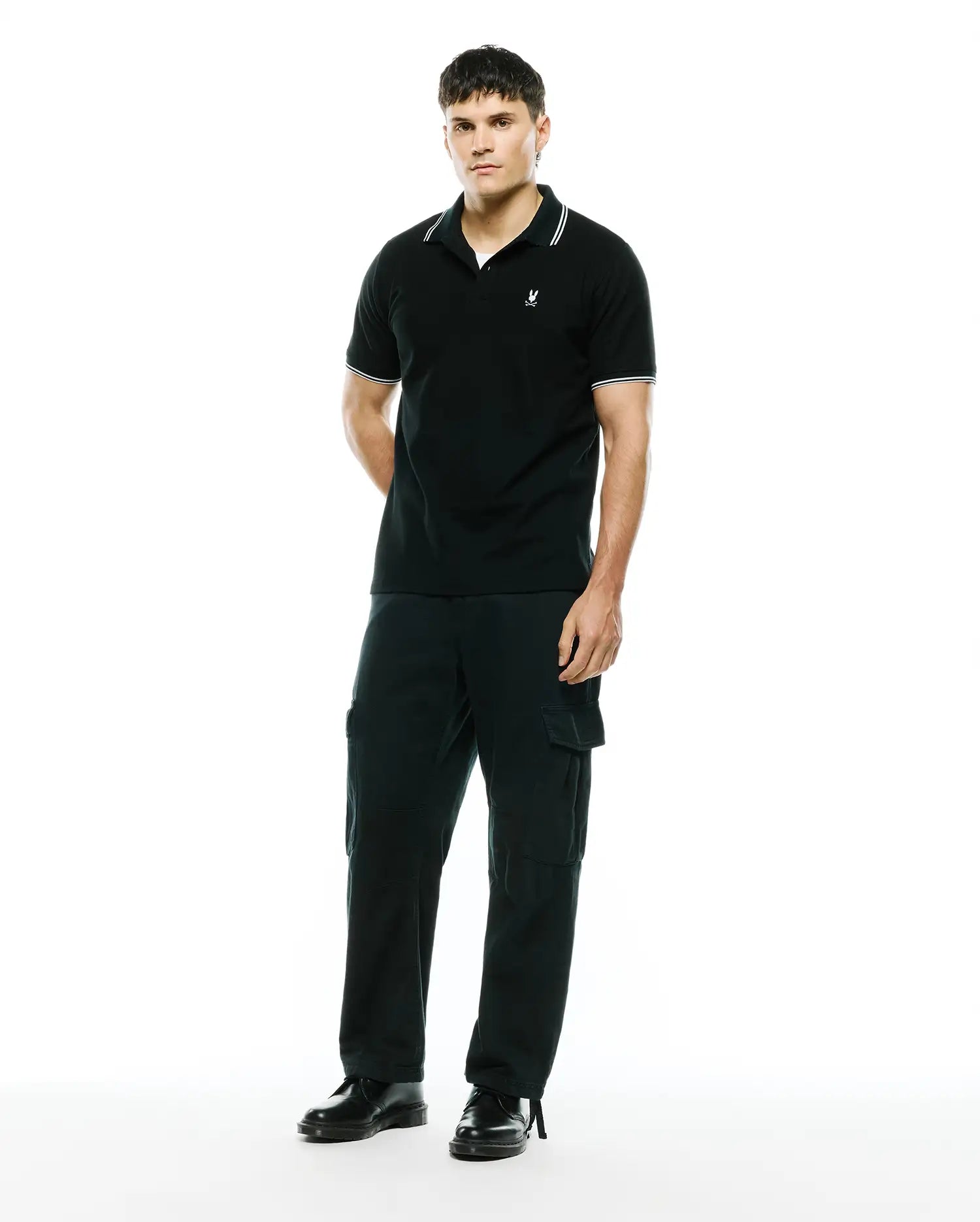 Mens Stan Pique Polo, black with white tipped collar and cuffs, featuring a small embroidered Psycho Bunny skull logo on the left chest in a classic pique knit.