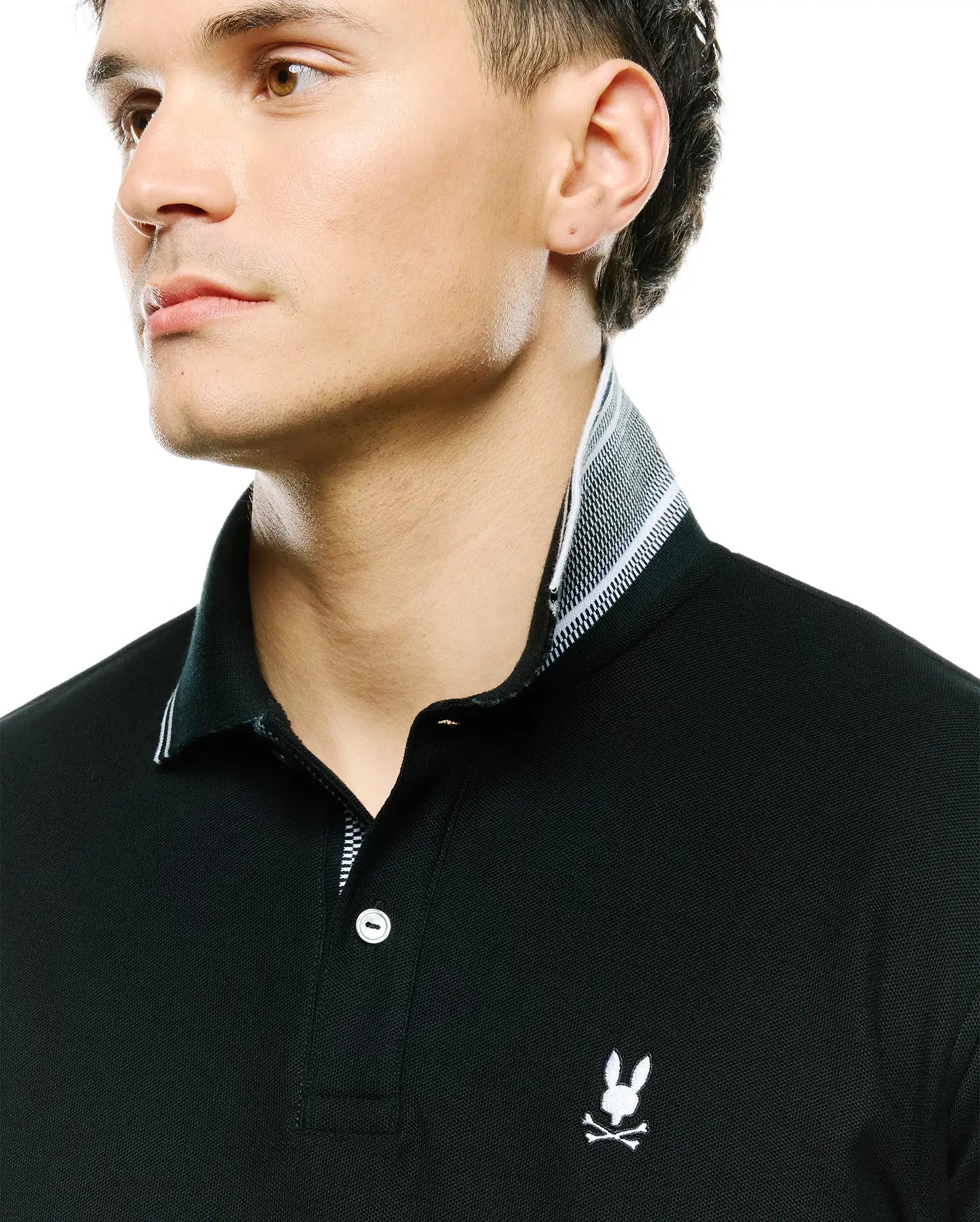 Mens Stan Pique Polo, black classic-fit pique polo with white embroidered Psycho Bunny skull logo on chest, white buttons, and a black and white striped inner collar.