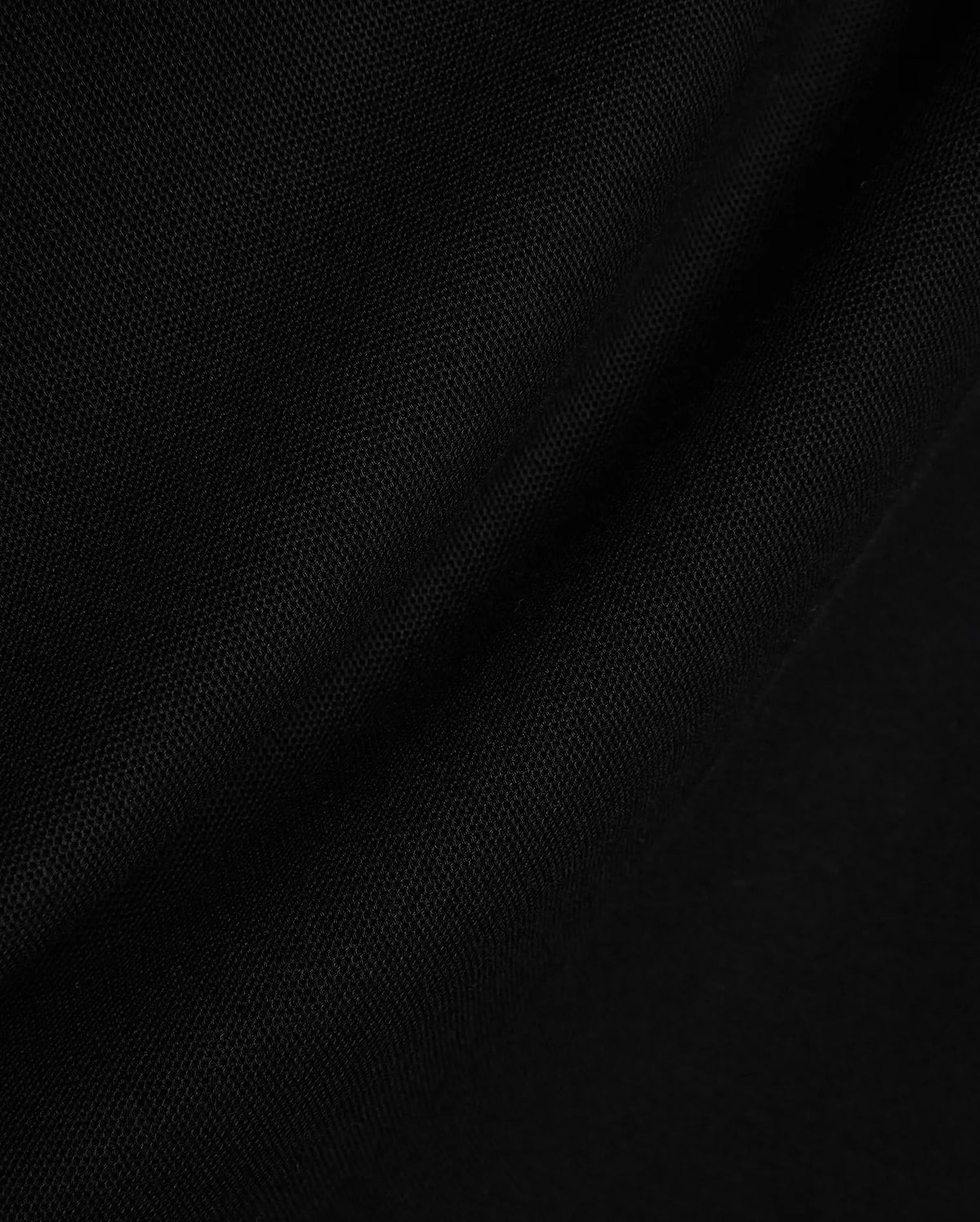 Black Mens Stan Pique Polo fabric, showcasing its premium, finely textured pique weave with subtle, elegant folds, ideal for refined streetwear.