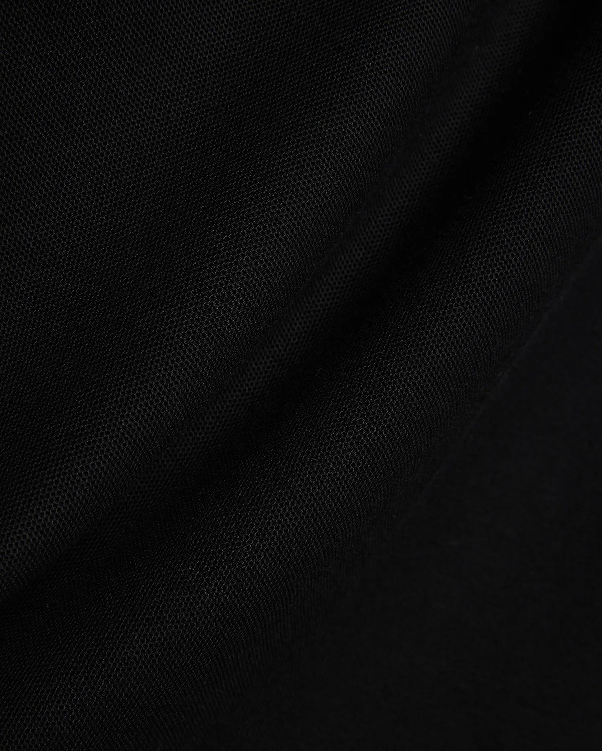 Black Mens Stan Pique Polo fabric, showcasing its premium, finely textured pique weave with subtle, elegant folds, ideal for refined streetwear.