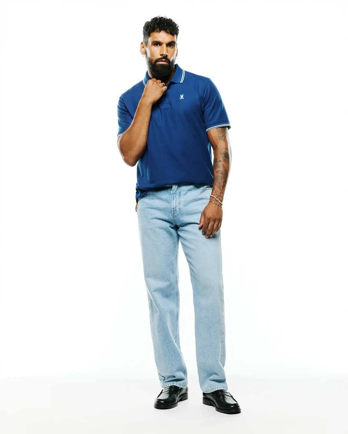 Mens Stan Pima Piqué Polo in deep blue, featuring a classic fit, textured piqué fabric, white tipped collar and cuffs, and a small embroidered Psycho Bunny skull logo on the left chest.