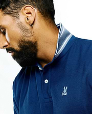 Mens Stan Pima Piqué Polo in deep navy blue, featuring a classic fit, textured piqué fabric, a ribbed collar with white stripes, and a small embroidered Psycho Bunny skull logo on the left chest.