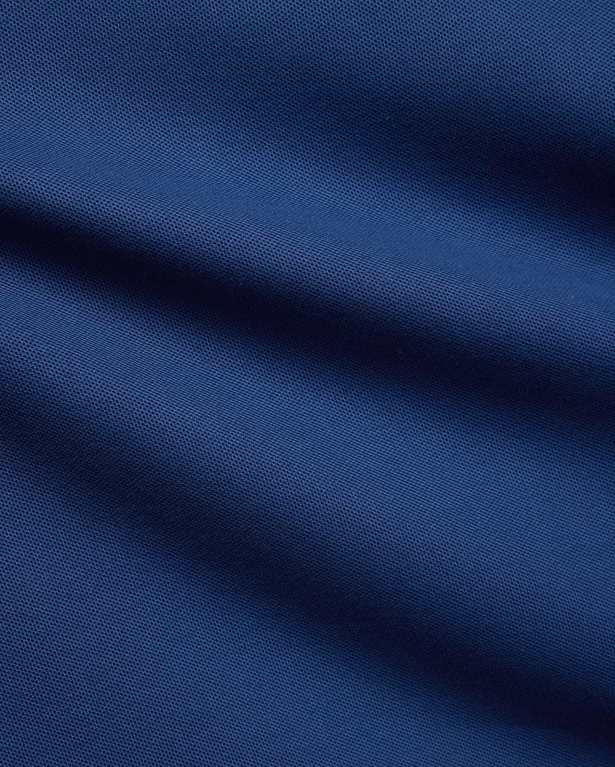 Mens Stan Pique Polo in a rich, deep blue, highlighting the classic textured pique weave, a premium and breathable fabric from Psycho Bunny menswear.