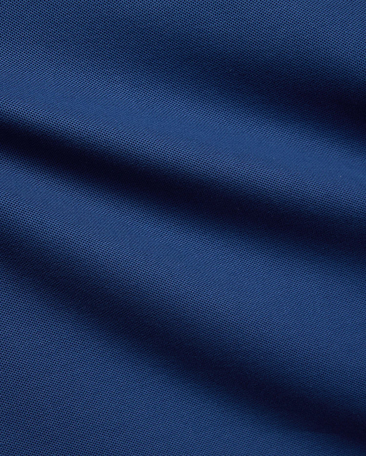 Mens Stan Pique Polo in a rich, deep blue, highlighting the classic textured pique weave, a premium and breathable fabric from Psycho Bunny menswear.