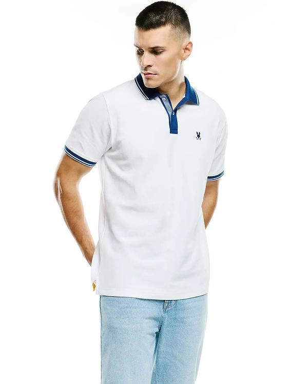 White Mens Stan Pima Piqué Polo, classic fit, with navy blue collar, striped placket, and striped cuffs. Small embroidered navy Psycho Bunny skull logo on left chest.