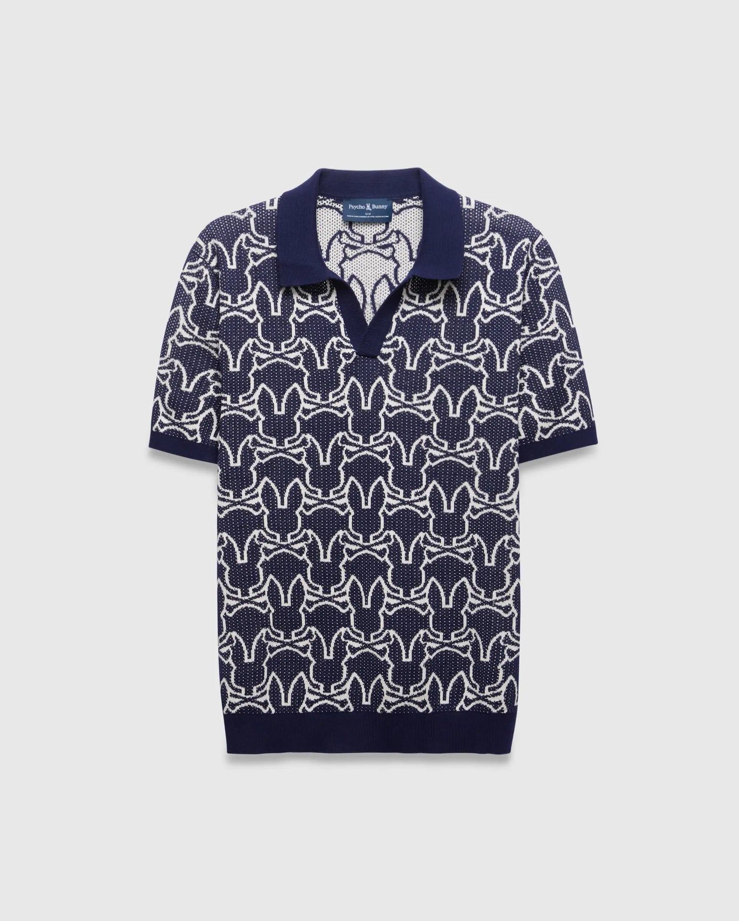 Mens Sidney Oversized Knit Polo in navy with a striking all-over white Psycho Bunny skull logo pattern, featuring a refined knit texture and classic collar.